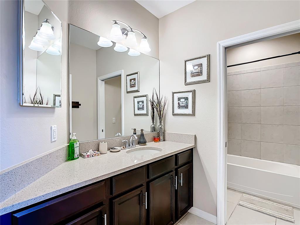 4744 Wandering Way Wesley Chapel, FL 33544 - Photo 27 of 39 a bathroom with a sink a large mirror and a shower