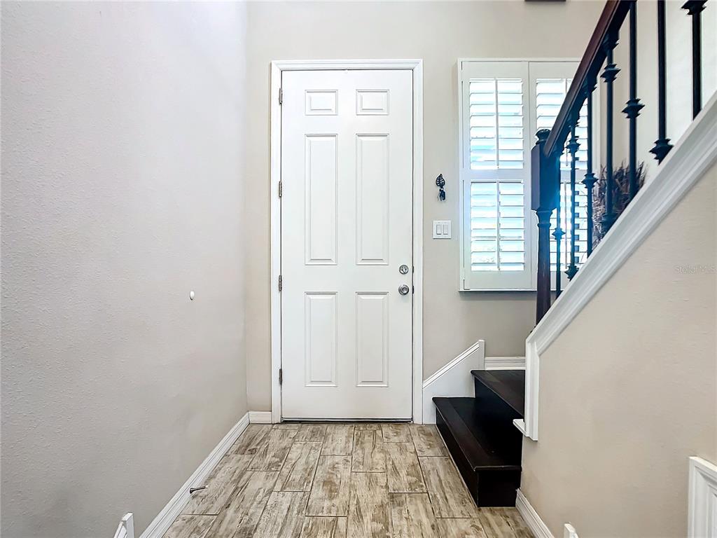 4744 Wandering Way Wesley Chapel, FL 33544 - Photo 4 of 39 a view of entryway with wooden floor and stairs