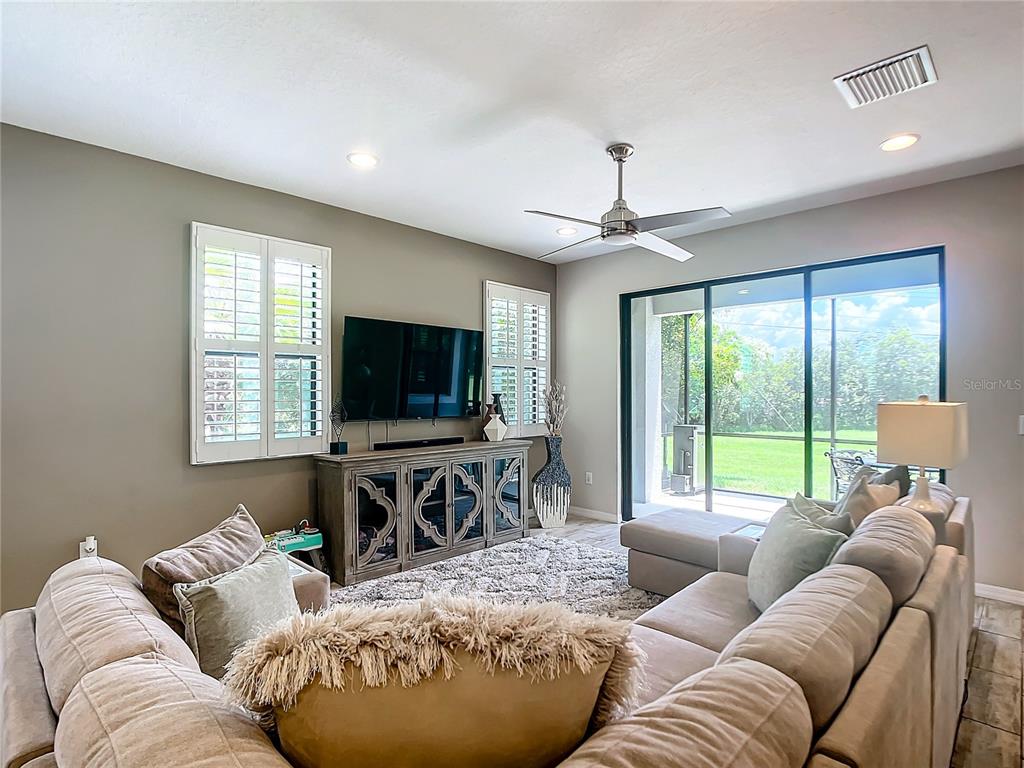 4744 Wandering Way Wesley Chapel, FL 33544 - Photo 7 of 39 a living room with furniture and a flat screen tv