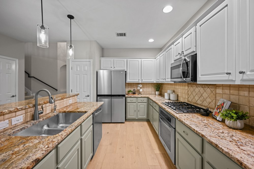 2823 Lantana Ridge Drive Austin, TX 78732 - Photo 11 of 34 a kitchen with stainless steel appliances granite countertop a sink a stove and a refrigerator