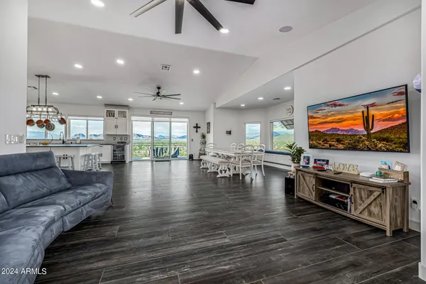 a kitchen with stainless steel appliances granite countertop a sink a stove and chairs with wooden floor