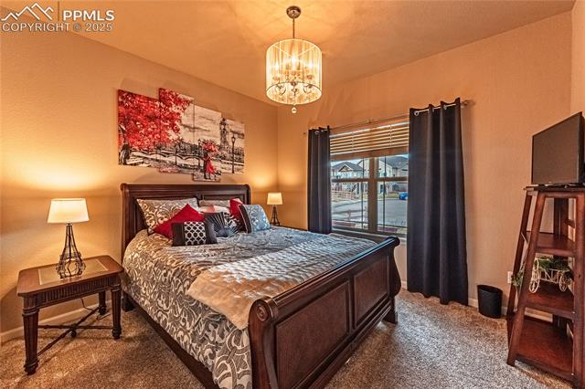 13812 Windy Oaks Road Colorado Springs, CO 80921 - Photo 4 of 50 Carpeted bedroom featuring a notable chandelier and baseboards