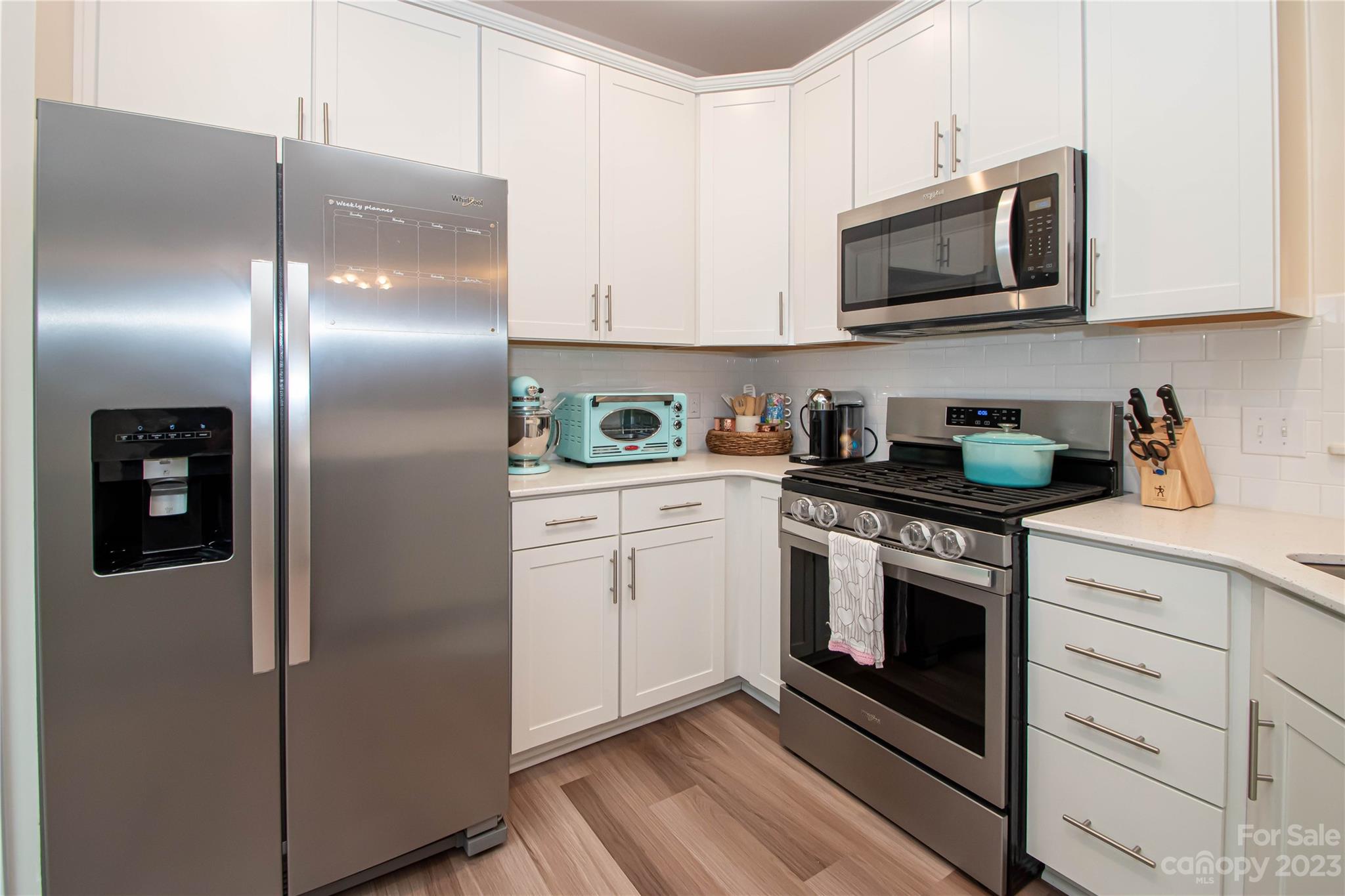 489 Hunters Dance Road Fort Mill, SC 29708 - Photo 10 of 36 a kitchen with cabinets stainless steel appliances and a wooden floor