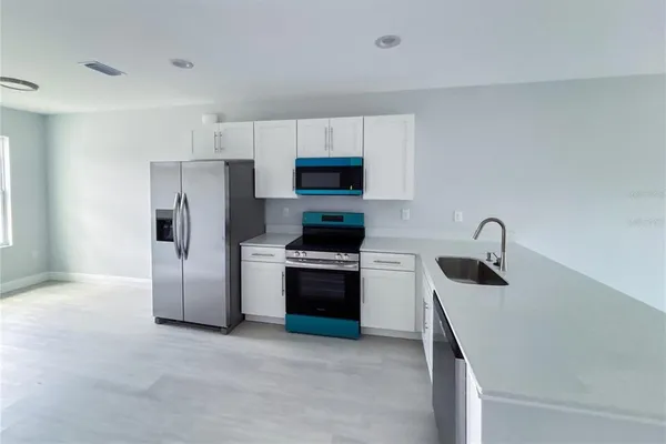 a kitchen with a refrigerator and a stove top oven