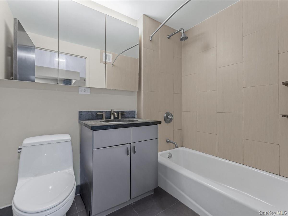 1810 3rd Avenue, Unit A2D Manhattan, NY 10029 - Photo 18 of 19 Bathroom with shower / washtub combination, vanity, and dark tile patterned floors