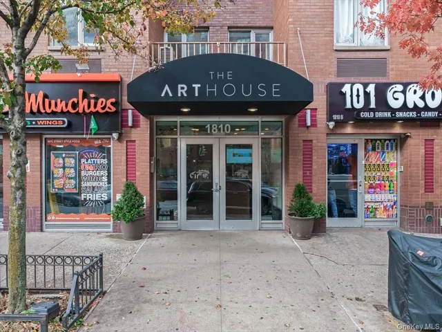 a front view of a multi story building with retail shops