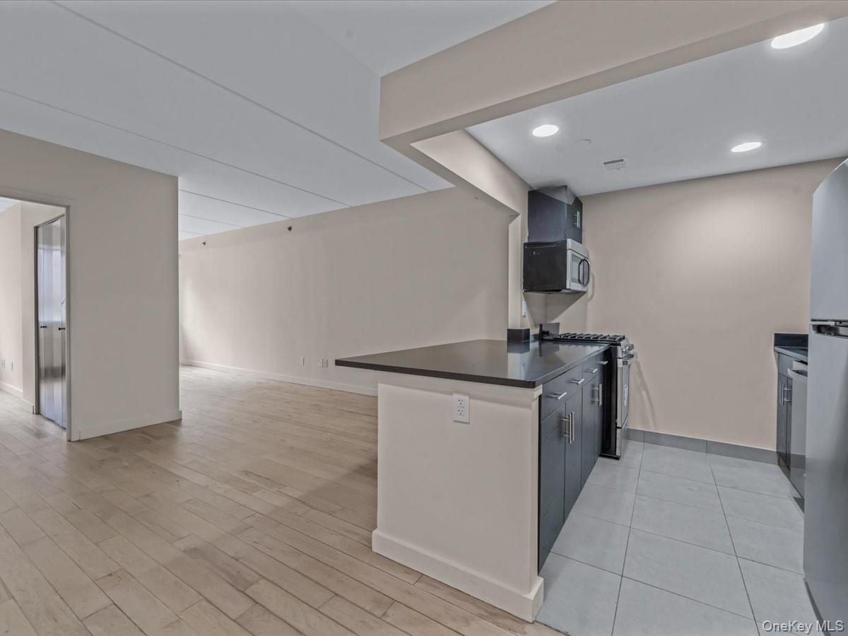 1810 3rd Avenue, Unit A2D Manhattan, NY 10029 - Photo 19 of 19 Kitchen with a peninsula, appliances with stainless steel finishes, open floor plan, recessed lighting, and light wood-style flooring