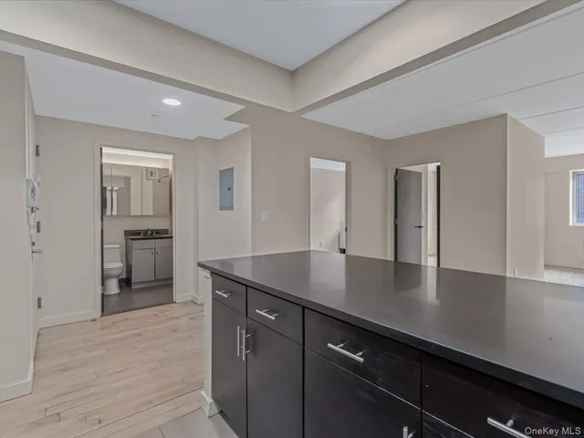 a kitchen with stainless steel appliances granite countertop a refrigerator a oven a sink a stove and a refrigerator with wooden floor