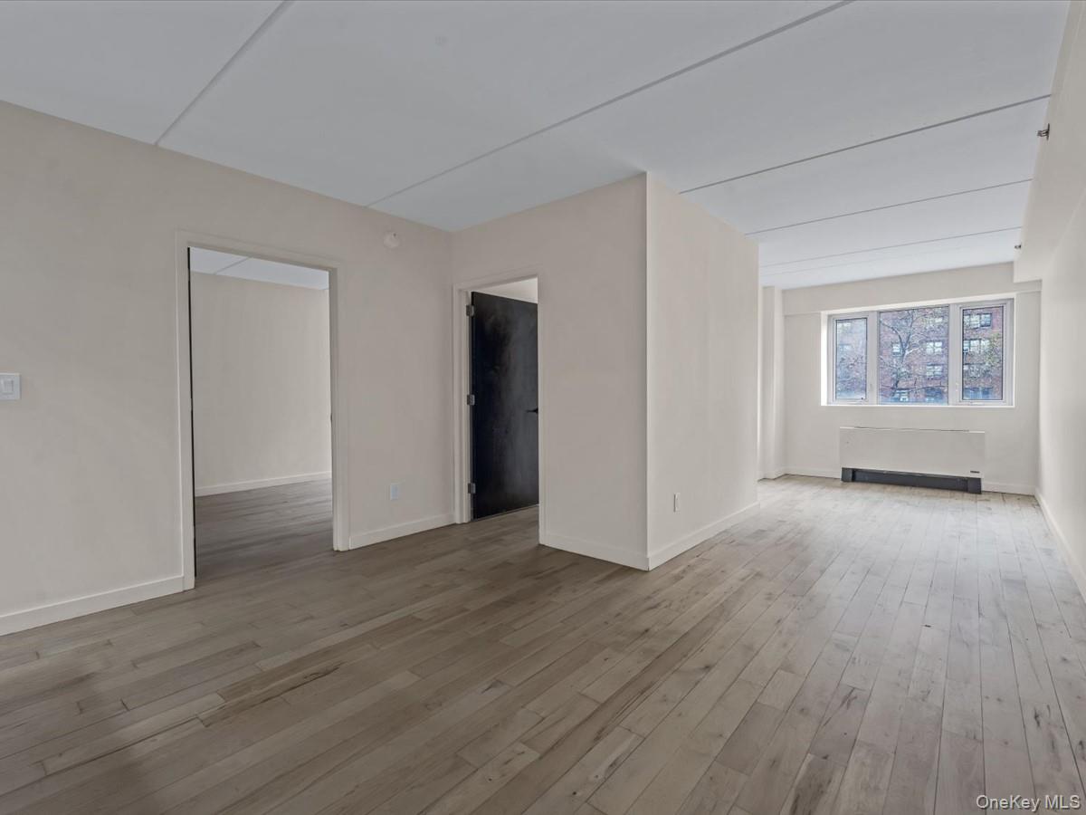 1810 3rd Avenue, Unit A2D Manhattan, NY 10029 - Photo 9 of 19 Spare room featuring light wood-type flooring and radiator heating unit