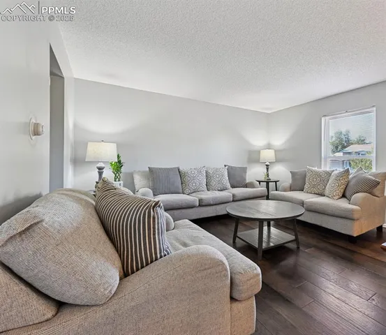 a living room with couches and a night stand