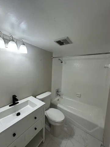 a bathroom with a sink mirror vanity and toilet