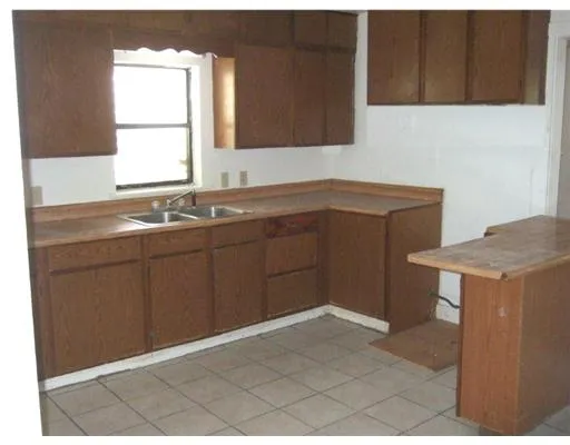 a kitchen with a sink cabinets and a window