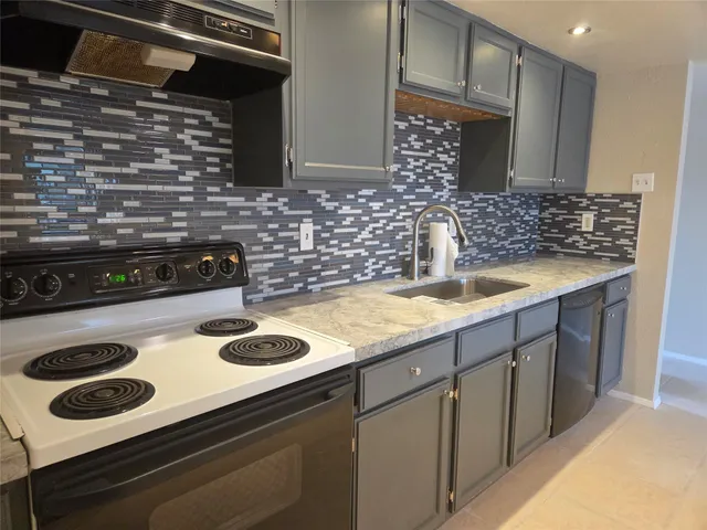 a kitchen with granite countertop a sink and stove