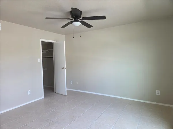 an empty room with a ceiling fan and a window