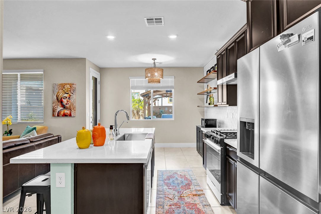 9688 Rankin Rdg Court Las Vegas, NV 89178 - Photo 12 of 53 A well-appointed kitchen features a large island and contemporary stainless steel appliances, creating a perfect space for entertaining.