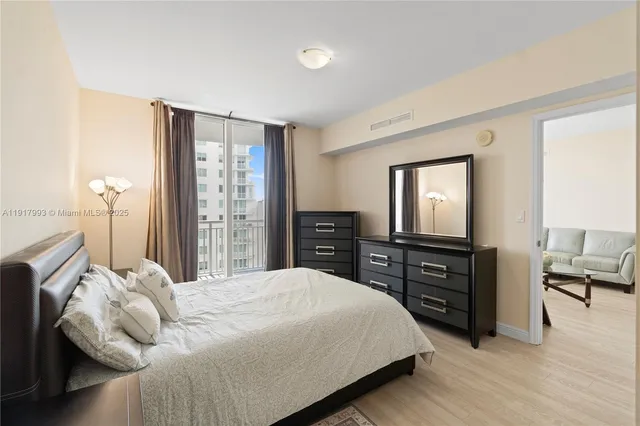 a bedroom with a bed and dresser with mirror