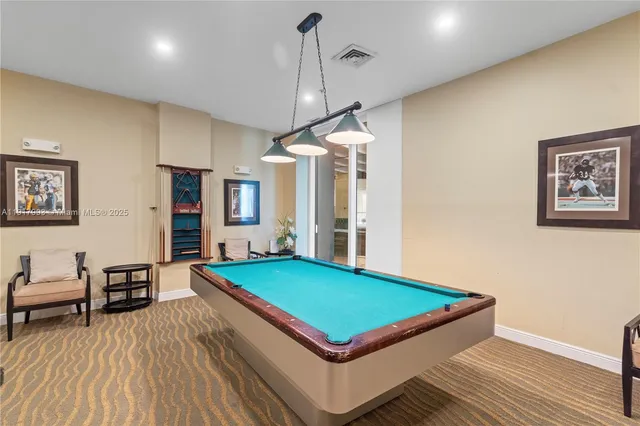 a room with pool table and windows