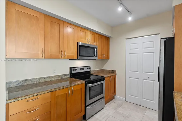 a kitchen with stainless steel appliances granite countertop white cabinets a stove top oven with wooden floor