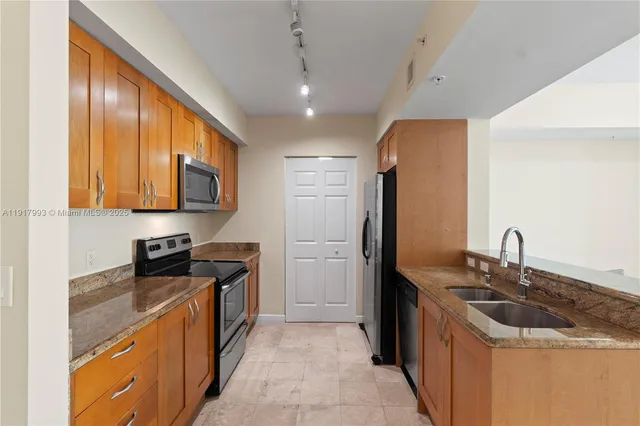 a kitchen with stainless steel appliances granite countertop a sink stove and refrigerator