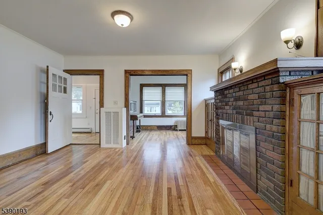 an empty room with wooden floor and fireplace