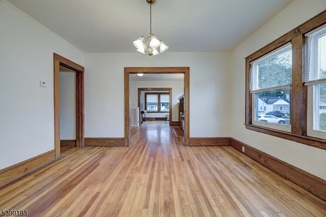 a view of a room with wooden floor chandelier and windows