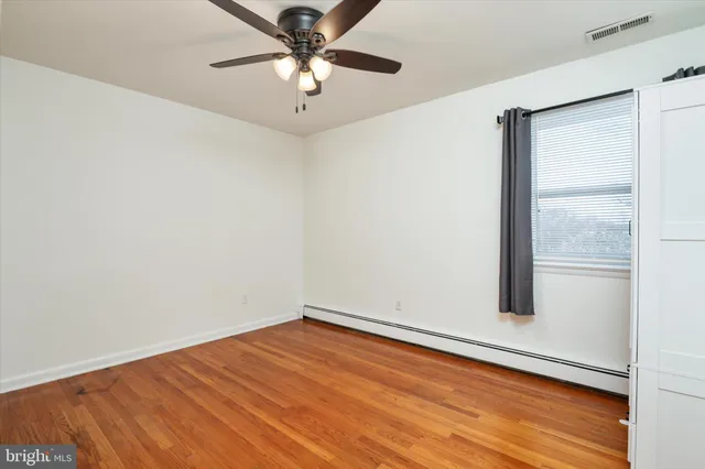 an empty room with a window and wooden floor