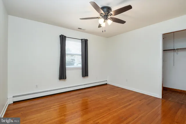 an empty room with a window and a ceiling fan