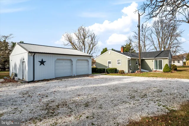 a view of large house with a large tree and wooden fence