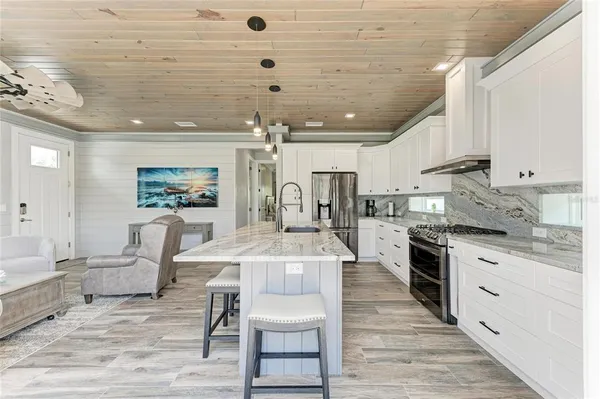 a large kitchen with cabinets wooden floor and stainless steel appliances