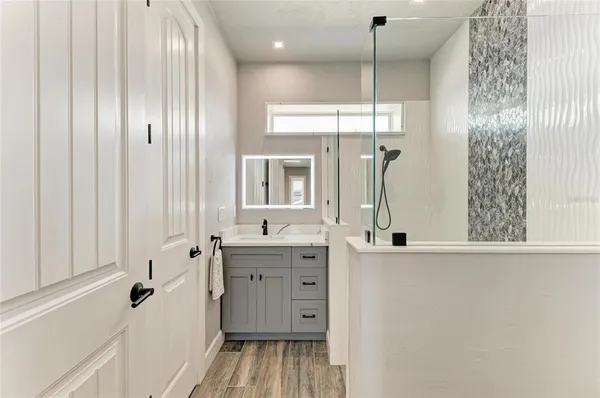 a bathroom with a double vanity sink a mirror and shower