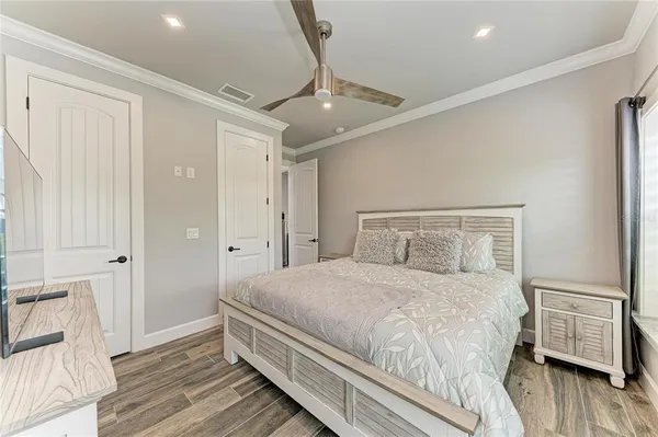 a bedroom with a bed and wooden floor