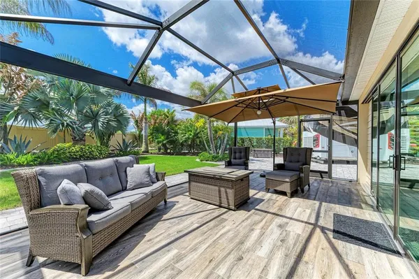 a view of a patio with couches and chairs under an umbrella