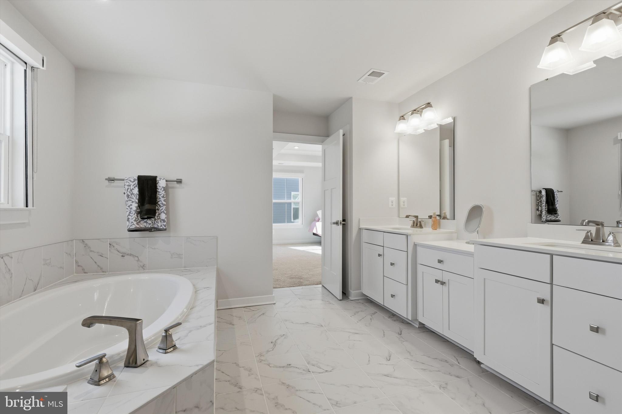 1321 Upper Patuxent Ridge Road Odenton, MD 21113 - Photo 23 of 82 a spacious bathroom with a tub sink double vanity and mirror