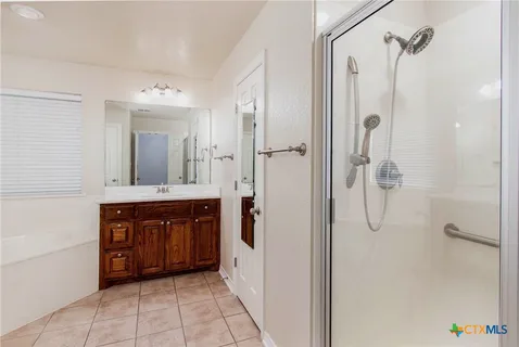 a spacious bathroom with a mirror sink and shower