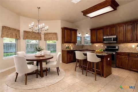 a kitchen with a dining table and chairs