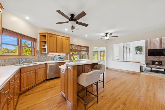 a living room with stainless steel appliances granite countertop furniture wooden floor and a kitchen view