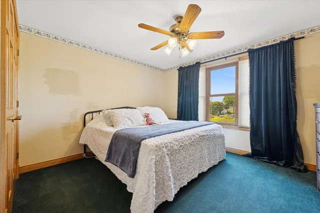 a bedroom with a bed and a large window