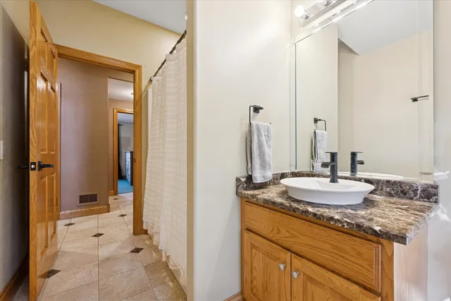 a bathroom with a granite countertop sink and a mirror