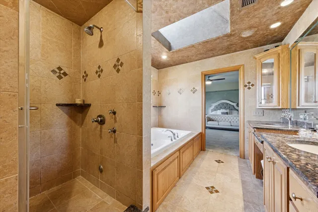 a bathroom with a tub sink shower and mirror