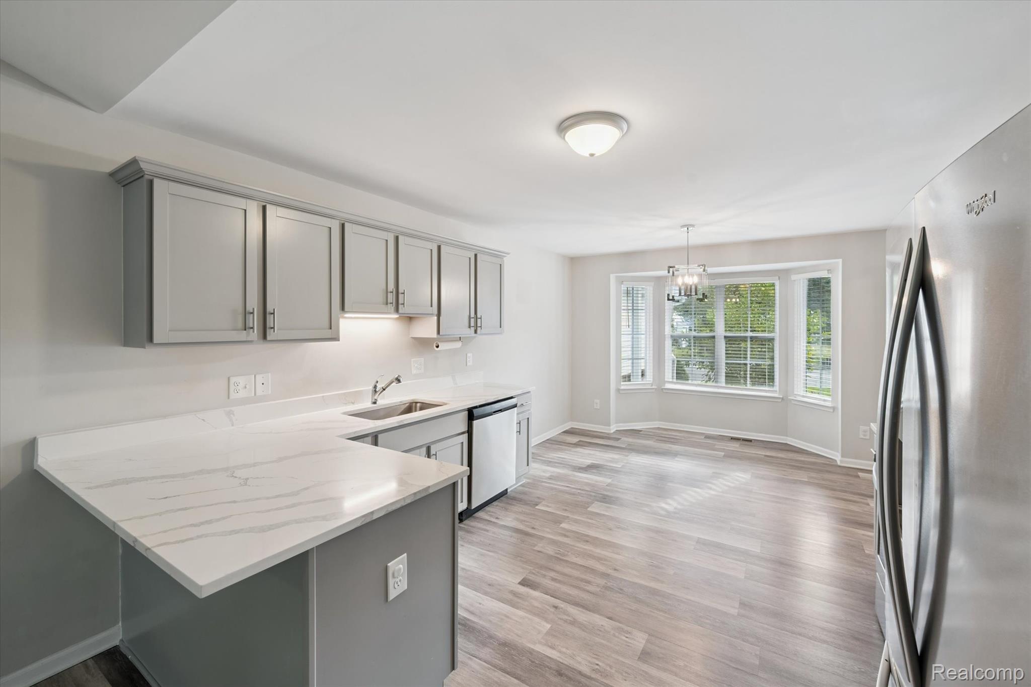 816 Nelson's Ridge Drive Howell, MI 48843 - Photo 6 of 36 Updated kitchen featuring quartz countertops, gray cabinetry, stainless steel appliances, and ample prep space.