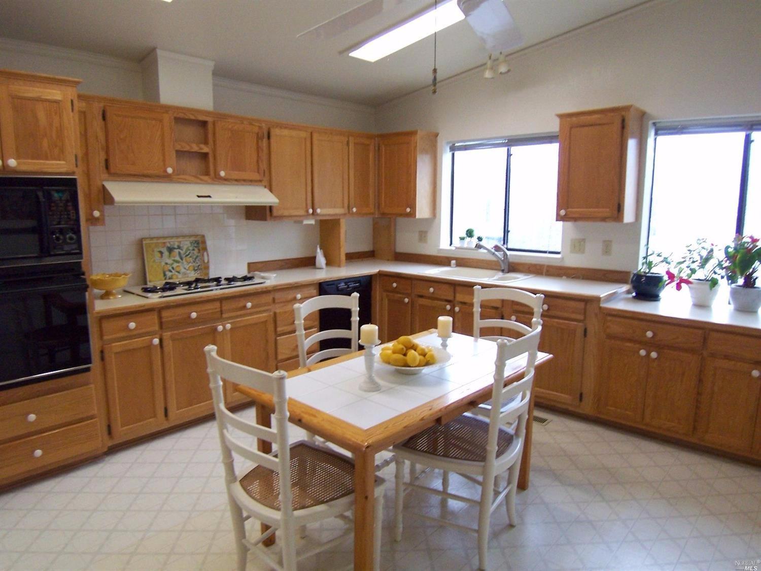 340 Acadia Lane, Unit 340 San Rafael, CA 94903 - Photo 1 of 1 a kitchen with a stove a sink dining table and chairs