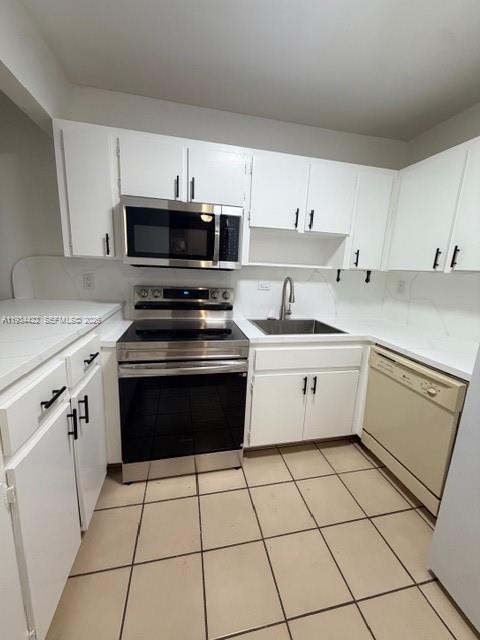 8990 Southwest 24th Street, Unit 215 Miami, FL 33165 - Photo 17 of 22 a white kitchen with granite countertop a stove top oven microwave and cabinets