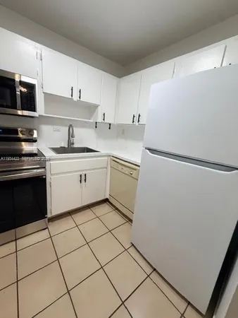 a kitchen with stainless steel appliances a refrigerator sink and cabinets
