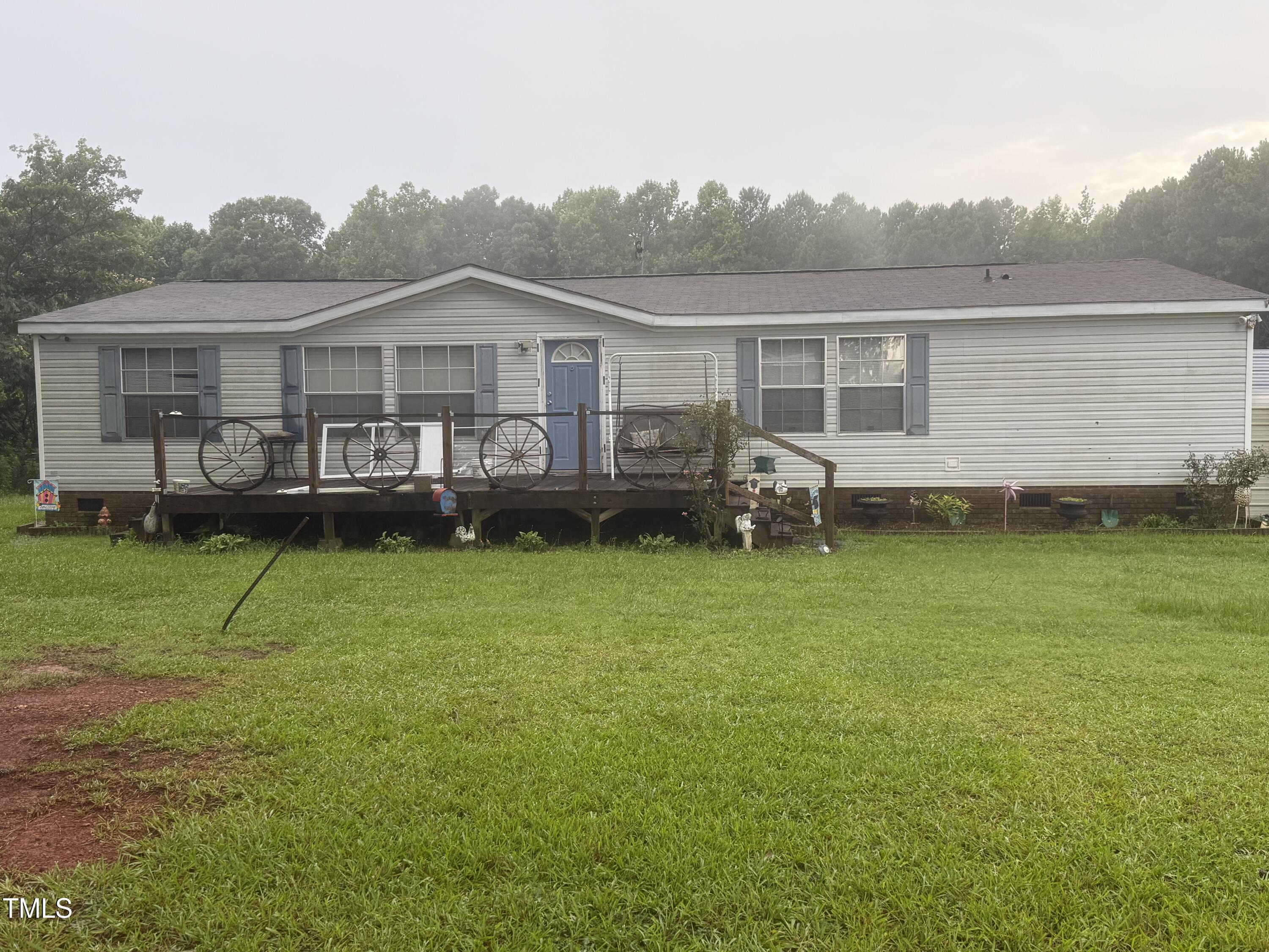 a front view of a house with a garden and lake view
