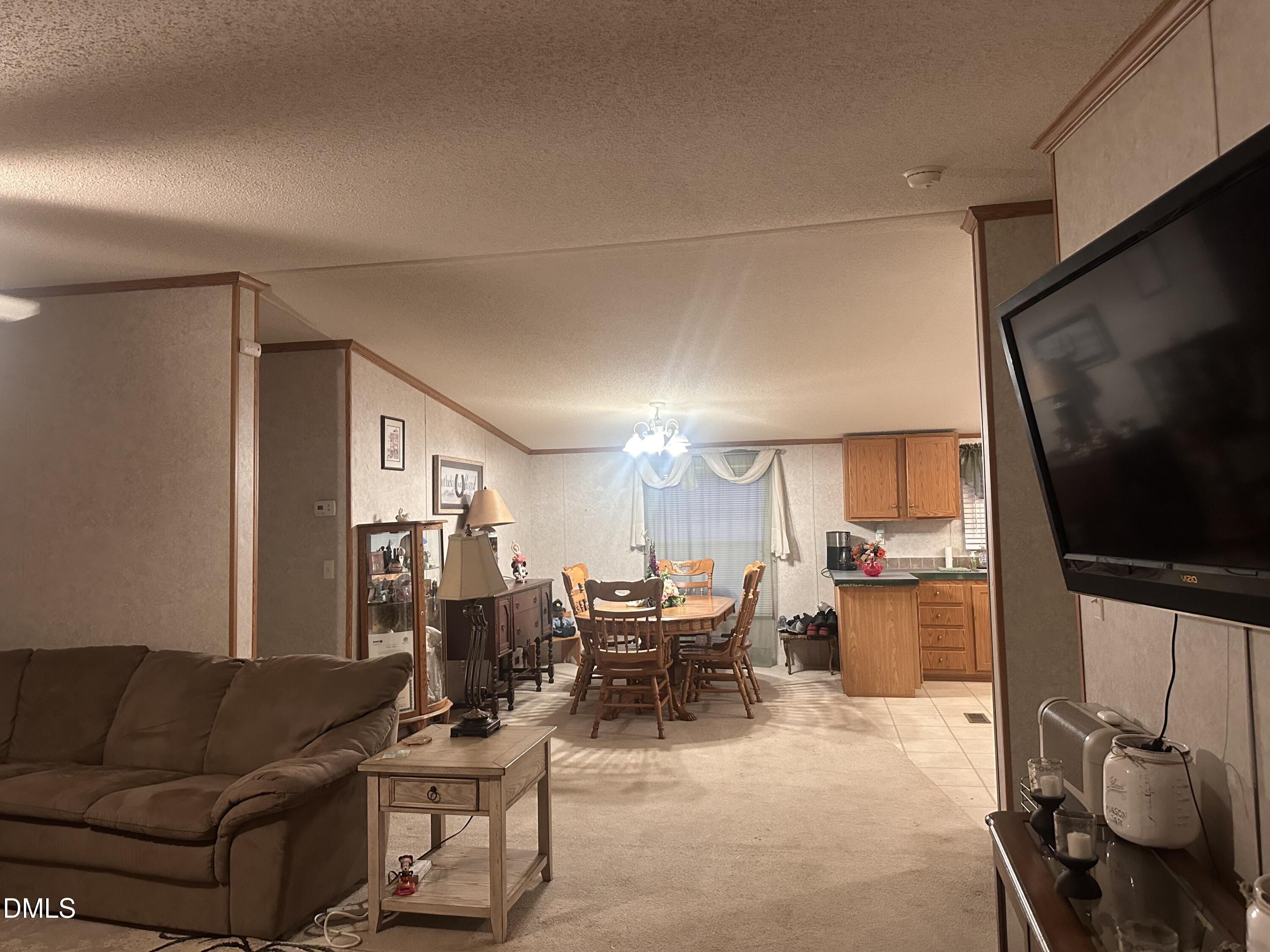10087 Highway 39 Middlesex, NC 27557 - Photo 12 of 17 a living room with furniture a flat screen tv and kitchen view