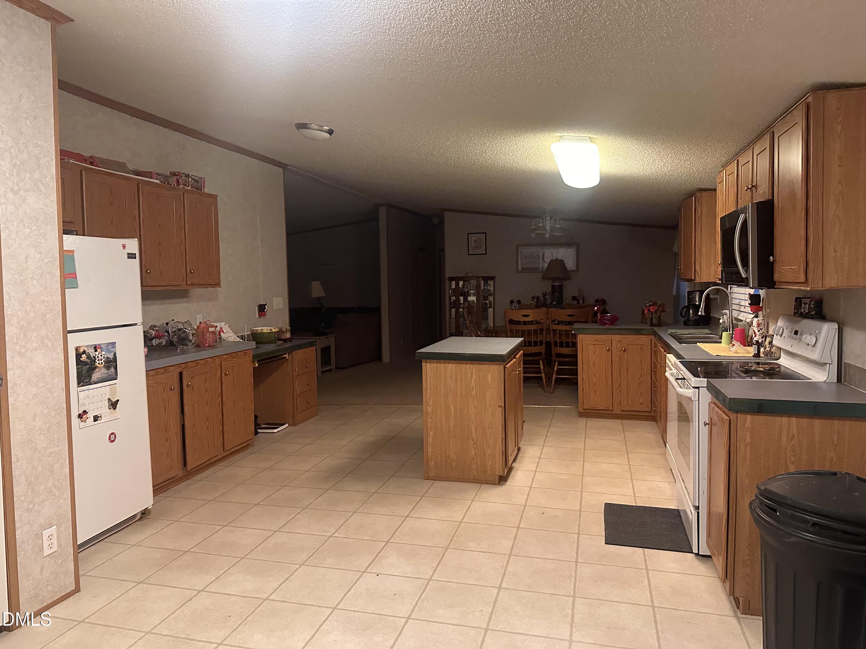 10087 Highway 39 Middlesex, NC 27557 - Photo 10 of 17 a kitchen with stainless steel appliances a refrigerator a sink a stove top oven a counter space and cabinets
