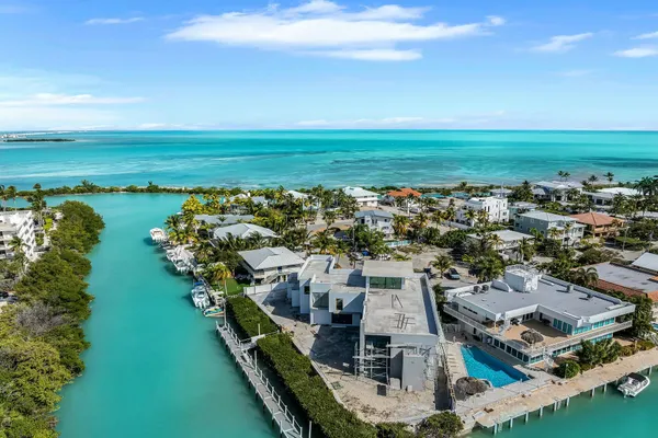 an aerial view of a city with lots of residential buildings ocean and mountain view in back