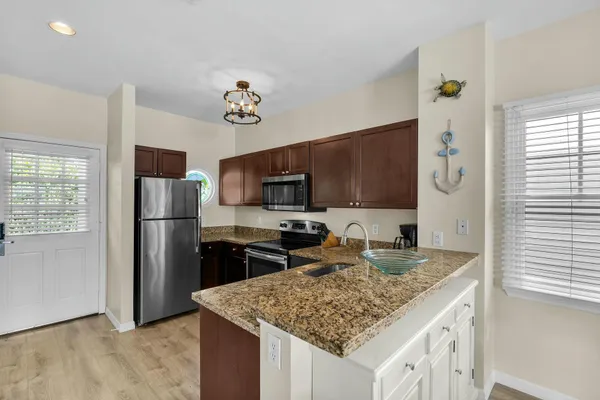 a kitchen with stainless steel appliances granite countertop a sink stove and refrigerator