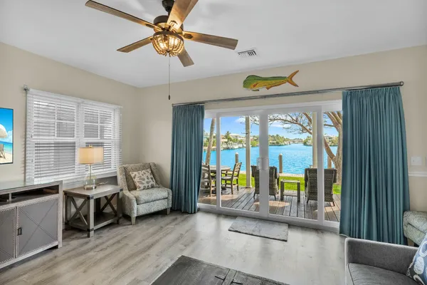 a kitchen with stainless steel appliances granite countertop a stove a sink a dining table and chairs with wooden floor