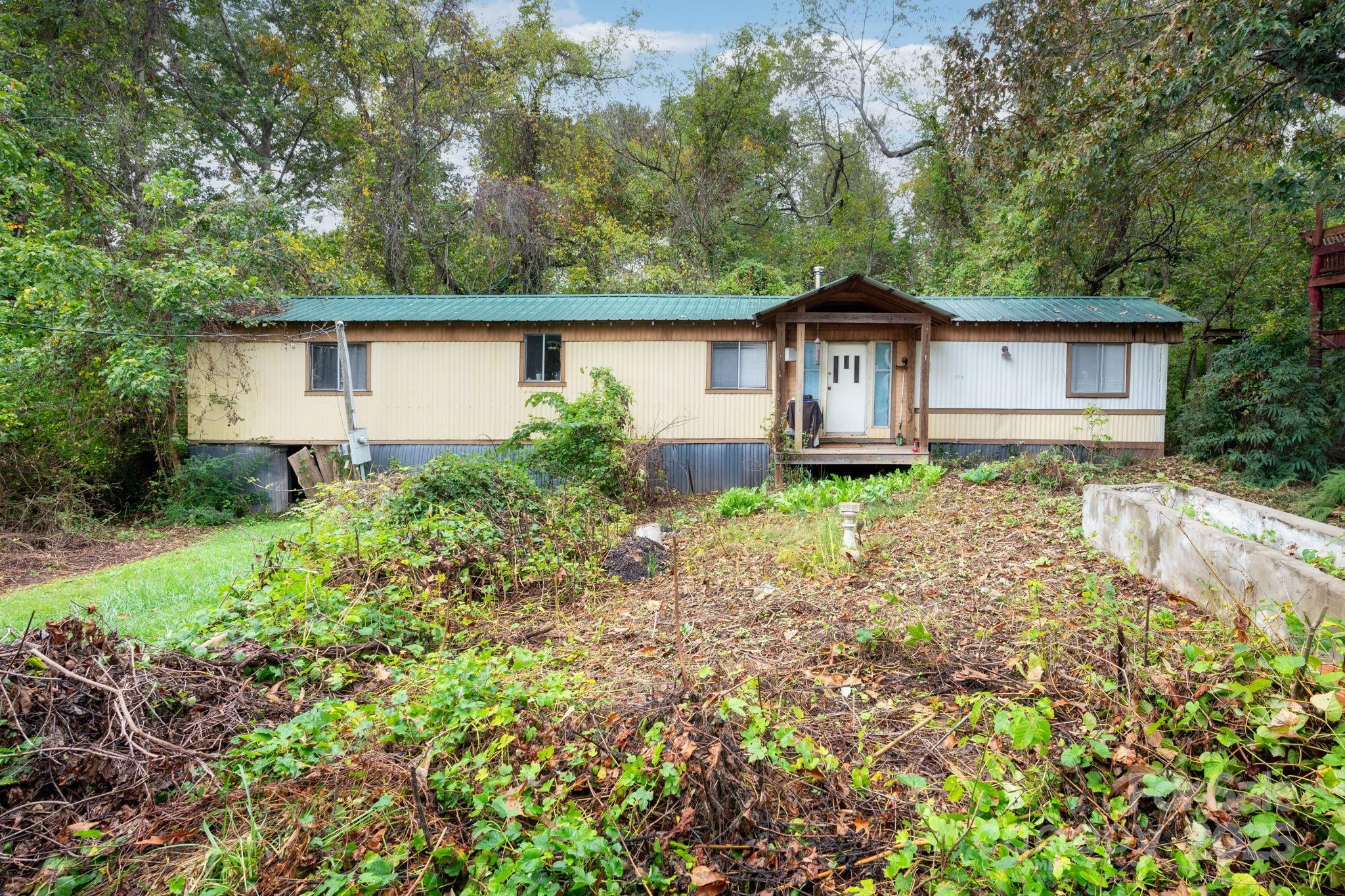 132 Little Knob Road Asheville, NC 28803 - Photo 2 of 18 a backyard of a house with plants and large trees